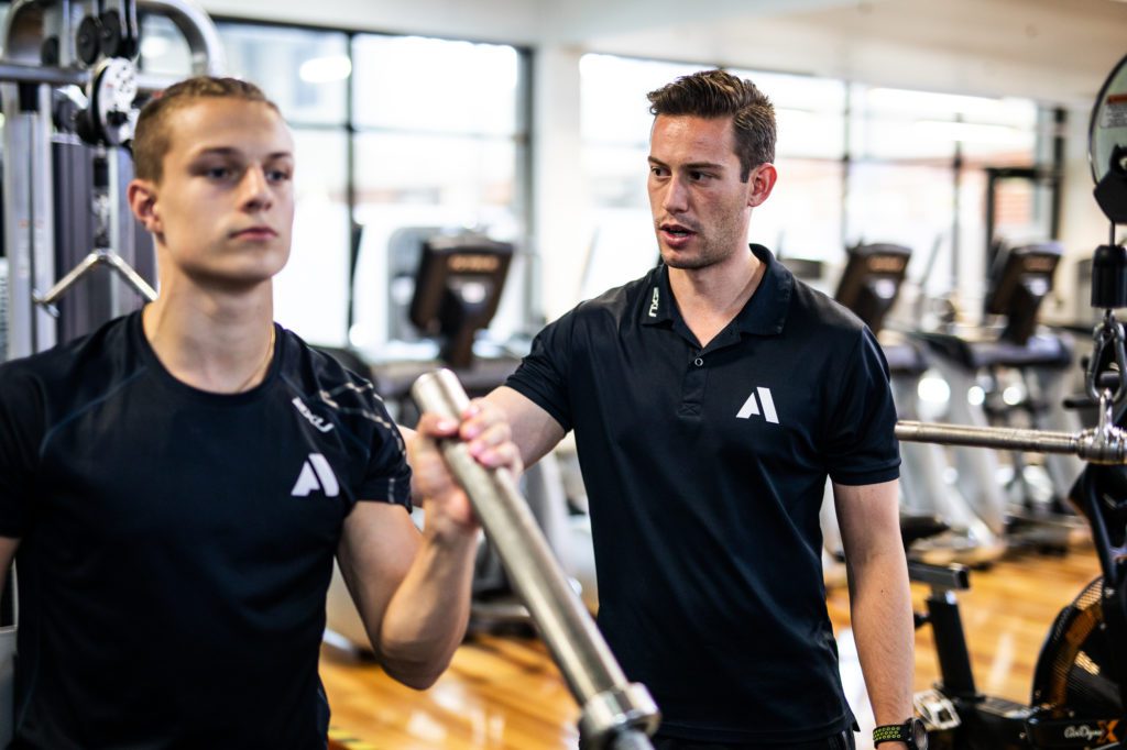 An Academy educator training a student in the gym